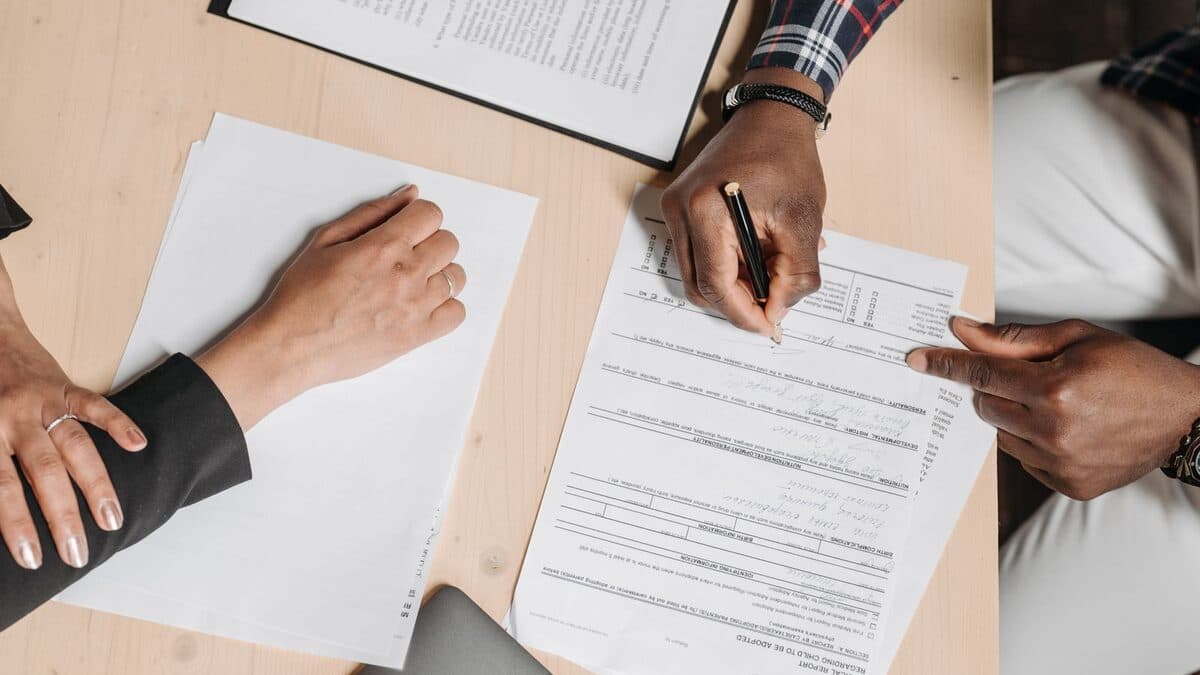 Deux personnes examinent et signent des documents administratifs liés au règlement d'une succession.