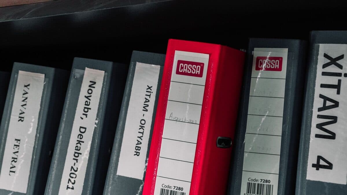 Rangées de classeurs de bureau colorés rangés sur une étagère de stockage de documents.