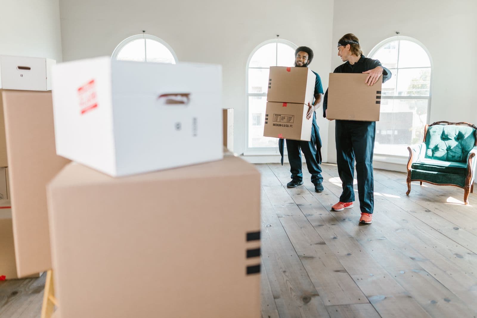 Déménageurs en uniforme portant des cartons lors d'un débarras de bureaux et locaux professionnels